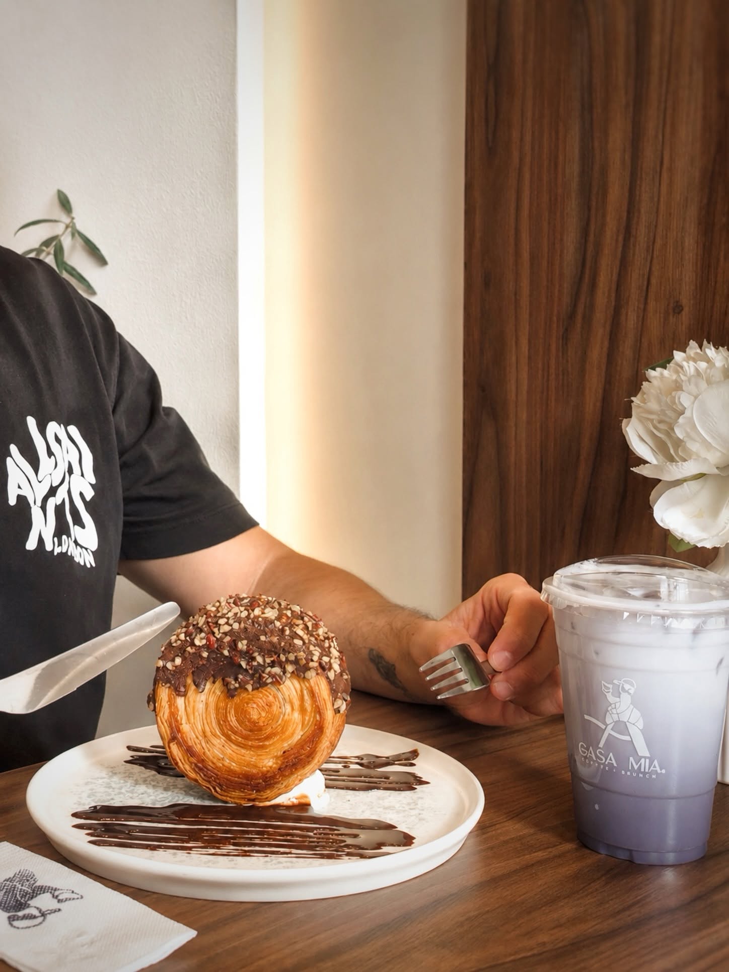 Rol de canela con nuez y chocolate acompañado de café helado